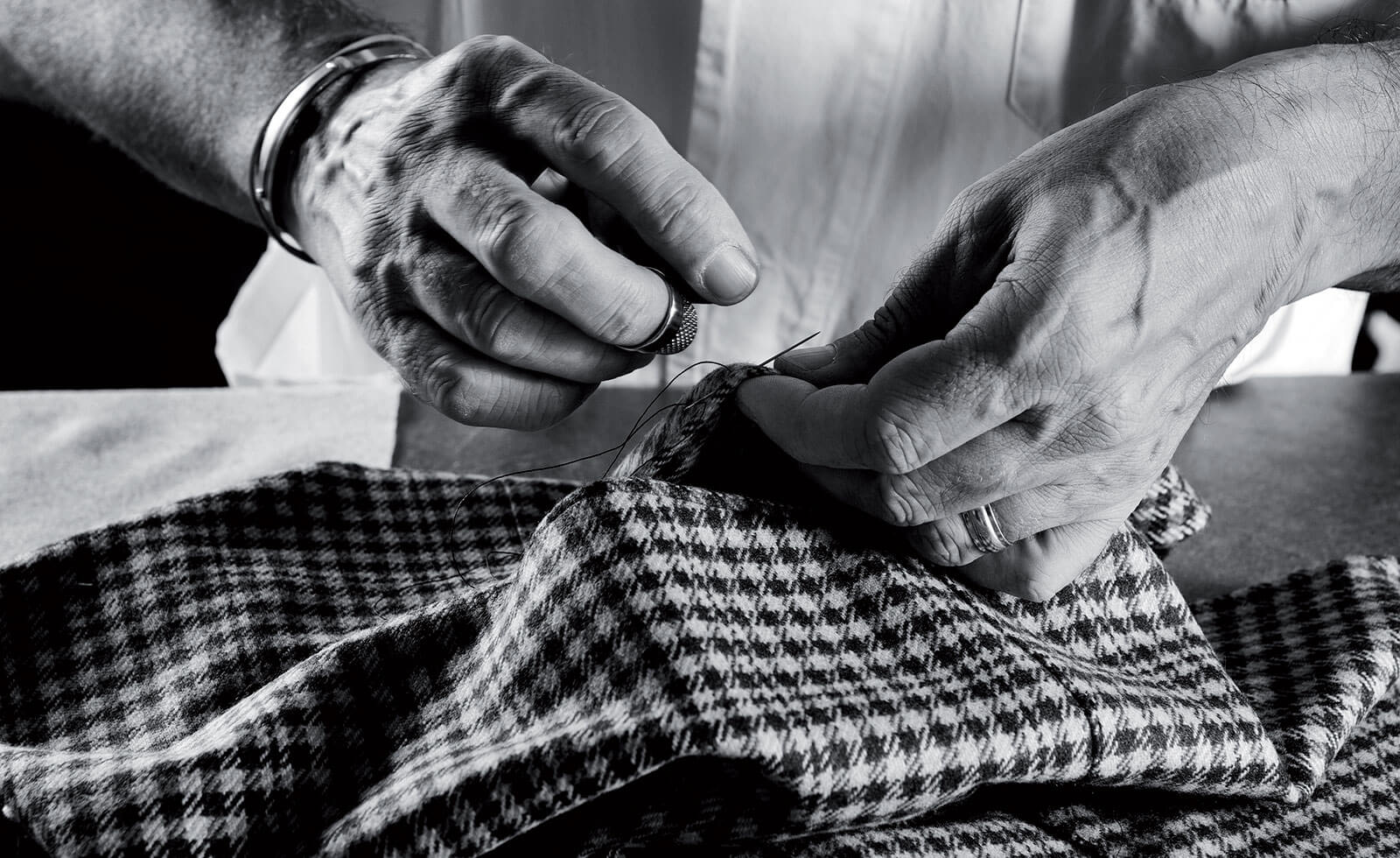 A tailor hand stitches patterned cloth in the Cesare Attolini atelier.