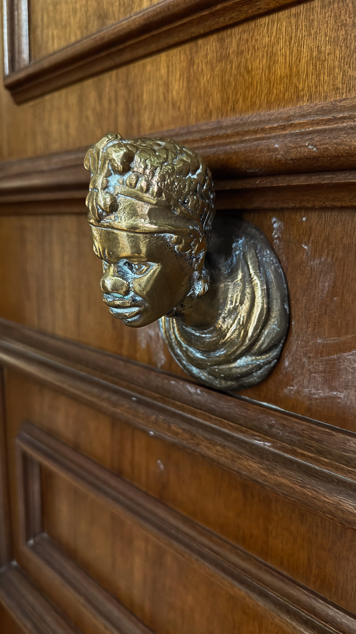 Un detalle esculpido en metal en una puerta de madera.