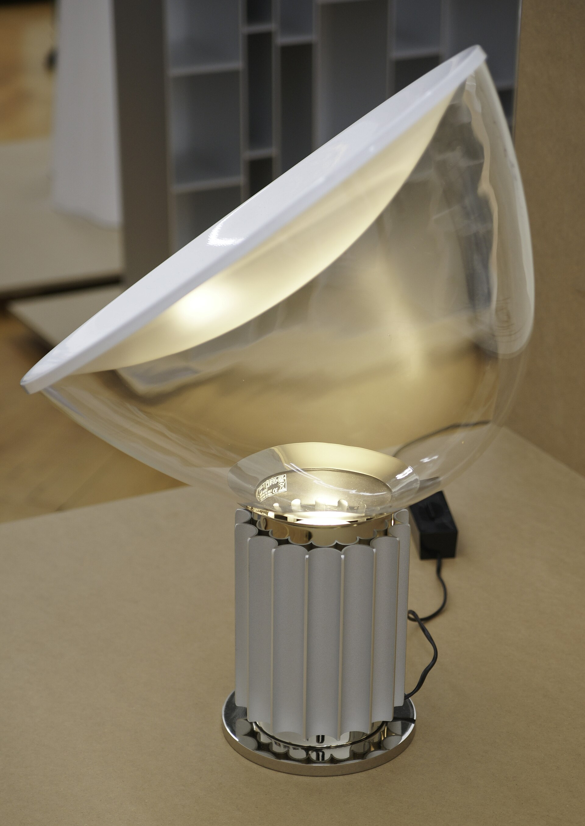 Die eingeschaltete Tischleuchte Taccia von Achille und Pier Giacomo Castiglioni in einer Ausstellung