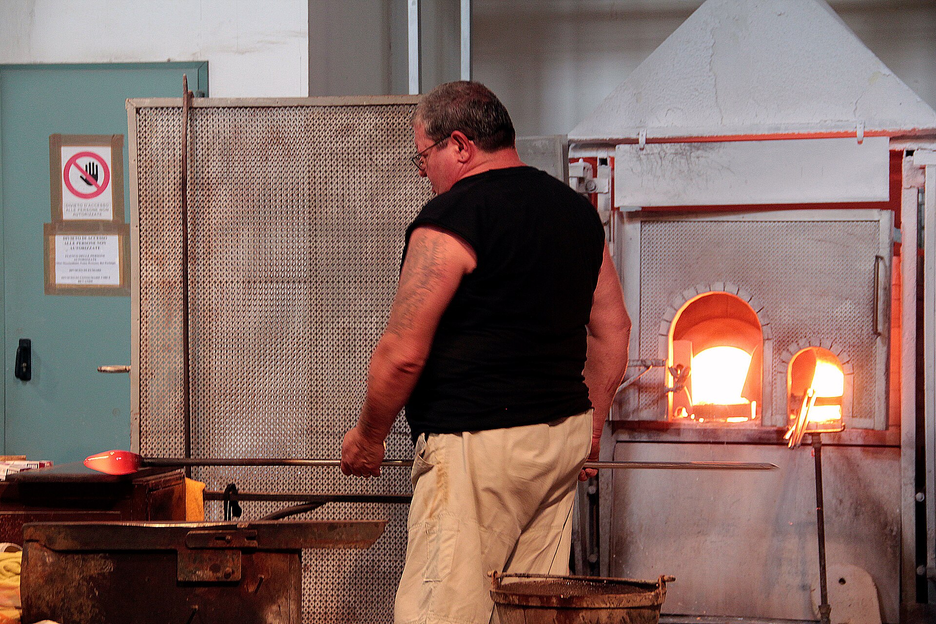 Ein Glasmacher formt geschmolzenes Glas bei Ferro & Lazzarini auf Murano