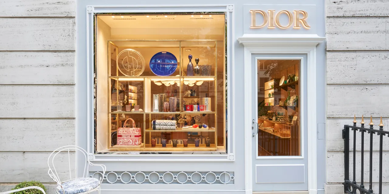 Die helle Fassade von Dior Maison mit beleuchteten Dekorationsobjekten im Schaufenster in Paris.