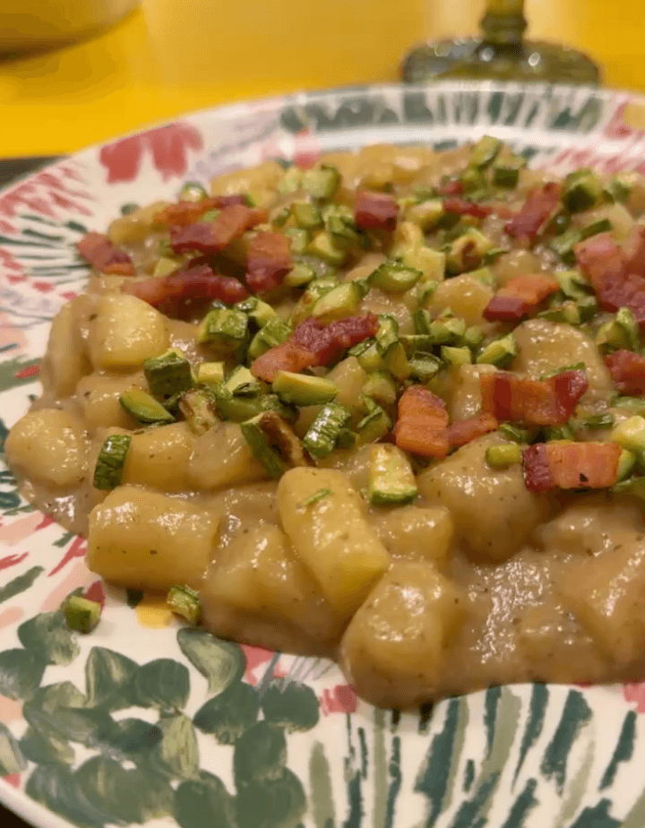 Gnocchi con zucchine a dadini su un piatto decorato.