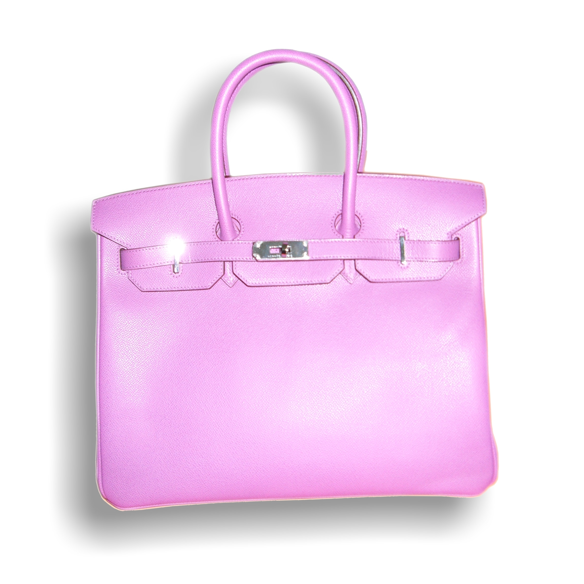 Un bolso Hermès Birkin rosa fotografiado sobre un fondo claro.
